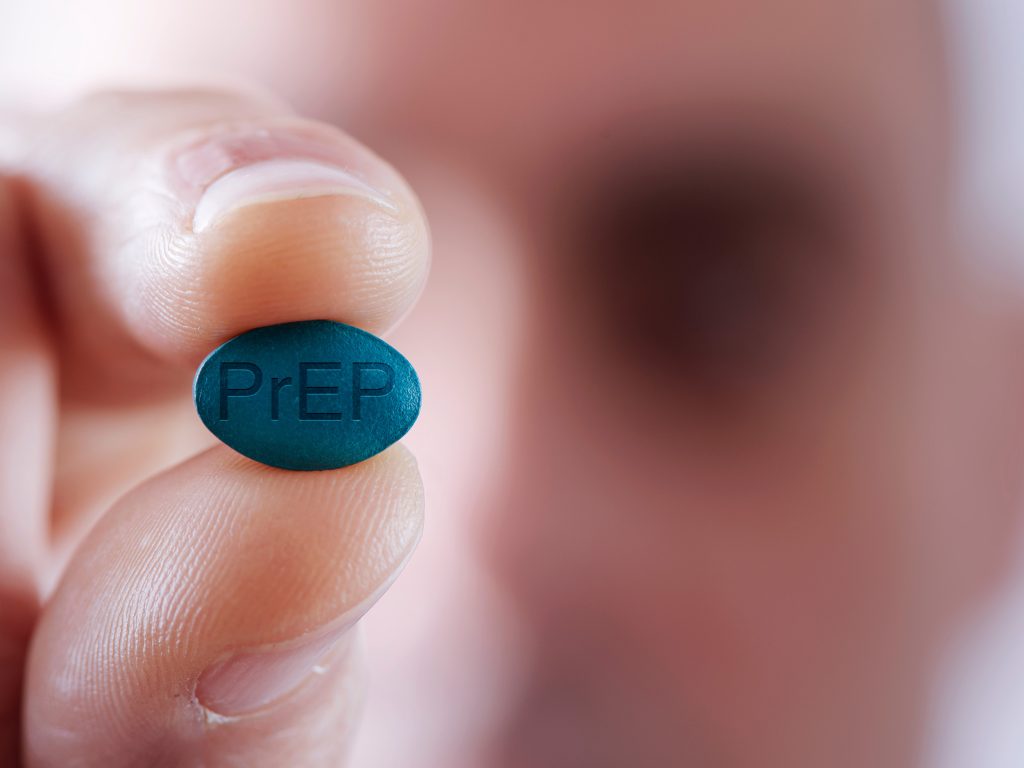 News 44 Close up of man holding a PrEP pill